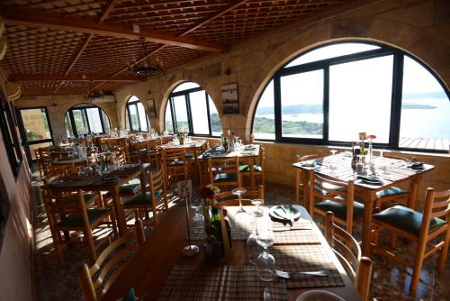 a dining room with tables and chairs and windows at Il-Bukkett B&B in Qala