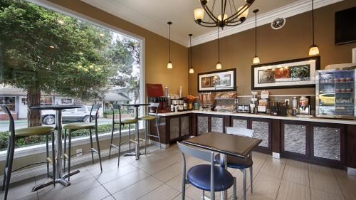 a bar in a restaurant with chairs and a table at Best Western Carmel's Town House Lodge in Carmel