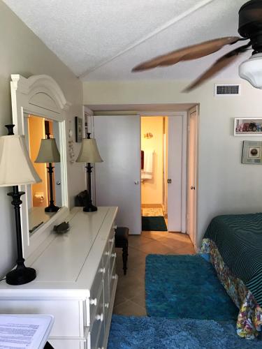 a bedroom with a bed and a dresser with a mirror at Crescent Arms 105N in Sarasota
