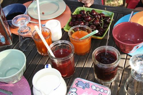 een houten tafel met glazen jam en fruit bij Ll POULIDETTO in Lioux