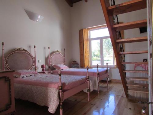two beds in a room with a window at Casa De Besteiros in Arneiro da Volta
