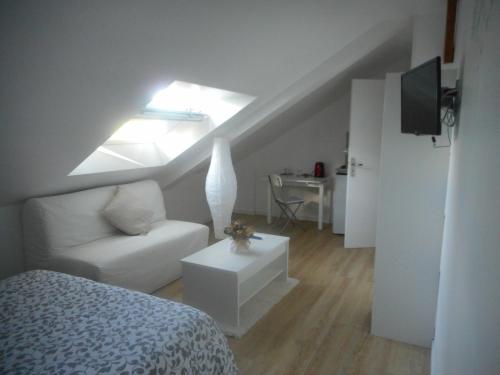 a attic room with a bed and a couch at Gadeyne Nathalie Le chalet de Malvoue in Vimoutiers