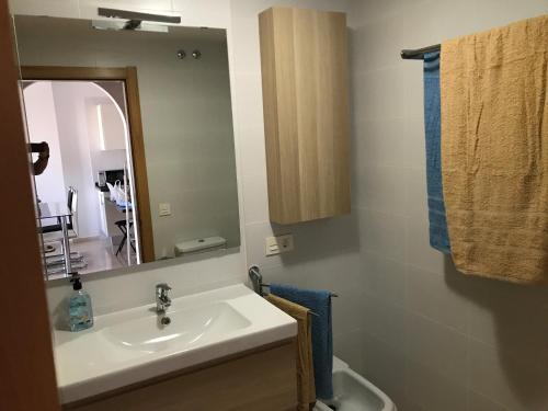 un bagno con lavandino e specchio di La Perla Medano 2 a El Médano