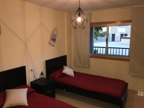 una camera da letto con due letti e una finestra di La Perla Medano 2 a El Médano