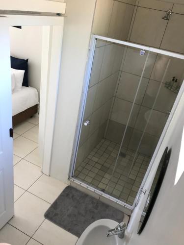 a glass shower in a bathroom with a toilet at 10 on Beresford in East London