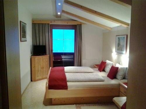 a bedroom with a large bed and a window at Ferienwohnung Hörbiger in Auffach