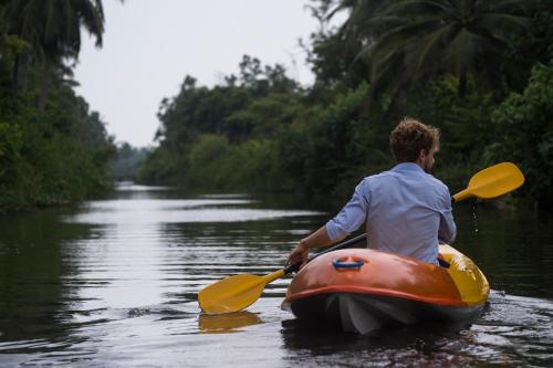 a man is in a kayak on a river at KAJU GREEN eco lodges in Unawatuna