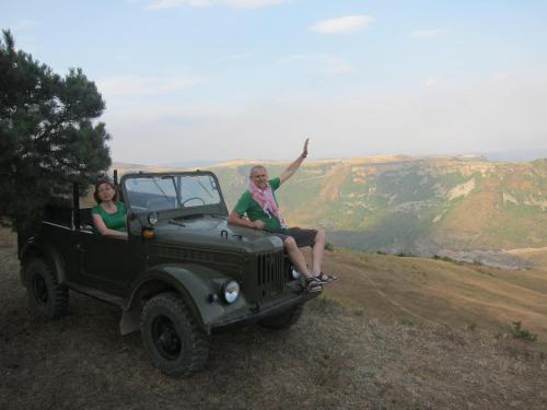 a man and woman sitting on the back of a green truck at Saro B&B and Safari Tours in Tatʼev