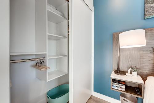 um quarto com uma parede azul, uma secretária e uma cama em Marquee on 16th em Calgary
