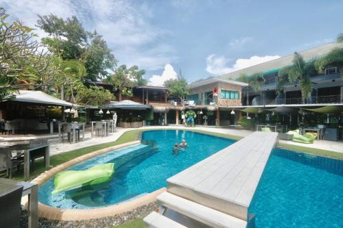 a large swimming pool with people in the water at Momento Resort in Pattaya South