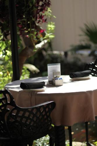 uma mesa branca com uma cadeira preta e uma mesa com uma toalha de mesa em Old Capitol Inn em Jackson