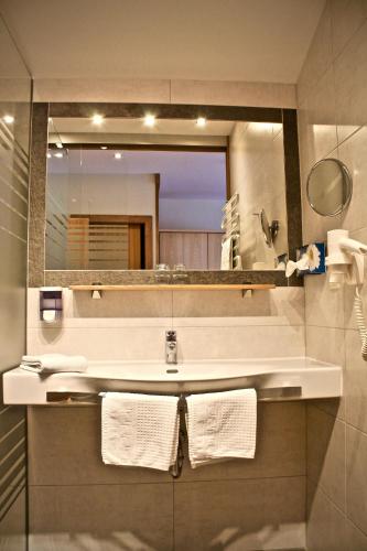 a bathroom with a sink and a mirror at Hotel Druschhof in Schladming