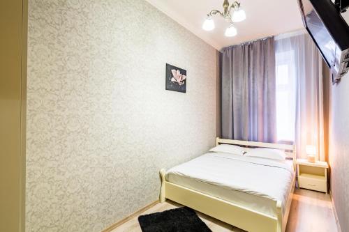 ein kleines Schlafzimmer mit einem Bett und einem Fenster in der Unterkunft Alfa Apartments Balabana 20 in Lwiw