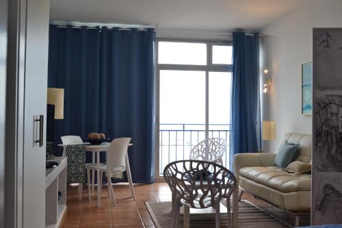 a living room with a couch and a table with chairs at Apartamento Vacacional con vistas al mar in Santa Cruz de Tenerife