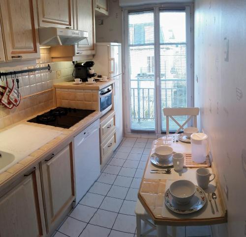 una cocina con una mesa con platos. en Apartment in Chessy very near Disneyland, en Chessy