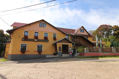a large yellow house with flowers in the window at Hotel Restaurant Svejk in Bublava
