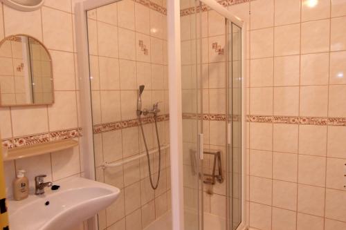 a bathroom with a shower and a sink at Hotel Restaurant Svejk in Bublava