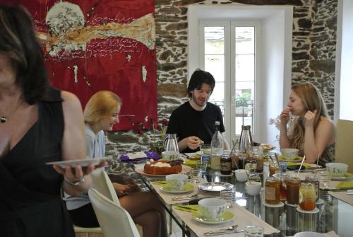 Un groupe de personnes assises autour d'une table à manger dans l'établissement Latu Corsu - Côté Corse - Gites et chambres d'hôtes au Cap Corse, à Ersa