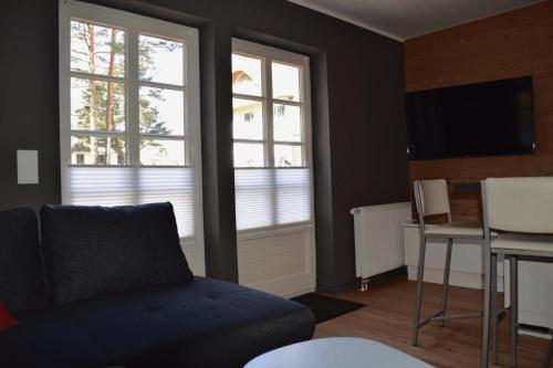 sala de estar con sofá, mesa y 2 ventanas en chalet Zingst en Zingst