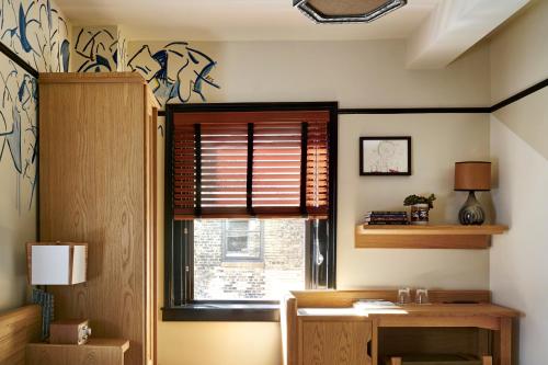 a room with a desk and a window with a window blind at Freehand New York in New York