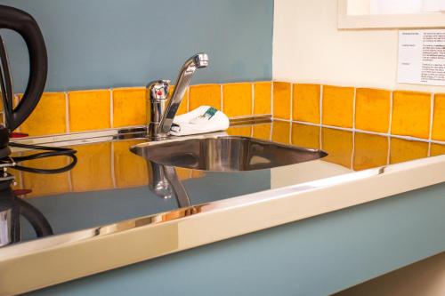 a sink in a bathroom with orange tiles at Bella Tuscany Motor Lodge in Napier