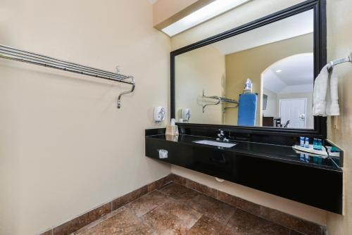 a bathroom with a black sink and a mirror at Scottish Inn and Suites Highway Six South in Mission Bend