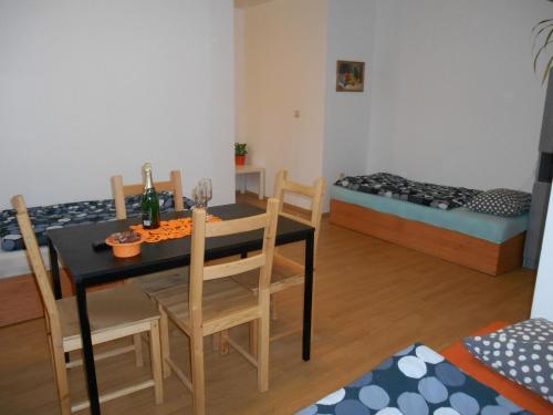 a dining room with a table and chairs and a bed at Penzion V Zatáčce in Plzeň