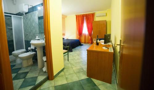 uma casa de banho com um lavatório, um WC e uma cama em La Lanterna em Martano