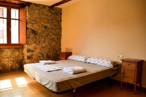 a bedroom with a bed with two towels on it at Ubilla Aterpetxea in Aulestia