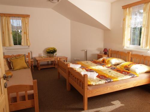 a bedroom with two beds and a table at Hotel Restaurant Svejk in Bublava