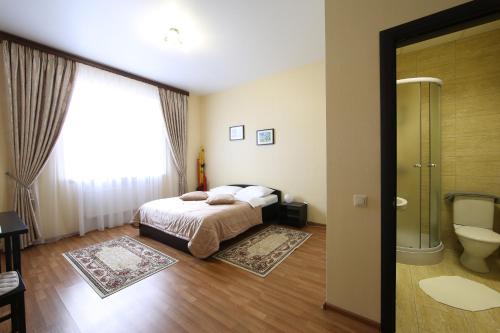 ein Schlafzimmer mit einem Bett und ein Badezimmer mit einem WC in der Unterkunft Smart People Eco Hotel in Krasnodar