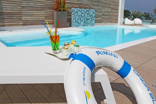 a swimming pool with a pool noodle stand next to a swimming pool at Hotel Villa Paola in Rimini