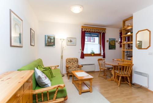 - un salon avec un canapé vert et une table dans l'établissement Apartma Sončnica, à Kranjska Gora