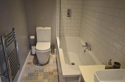 een badkamer met een toilet, een bad en een wastafel bij London, Kensington and Chelsea Flat in Londen