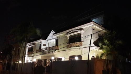 a white building with a balcony at night at Hotel Seven 7 in Karachi