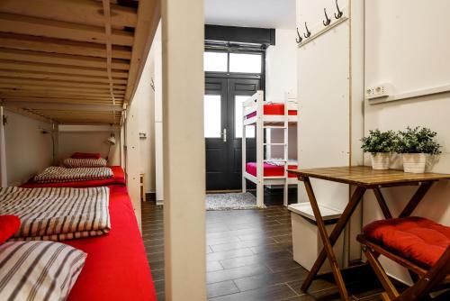 two beds in a room with a table and a desk at Turn Hostel in Ljubljana