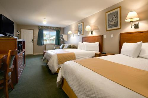 a hotel room with two beds and a television at Ramada Merritt in Merritt