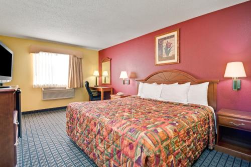 a hotel room with a bed and a television at Days Inn by Wyndham Torrington in Torrington