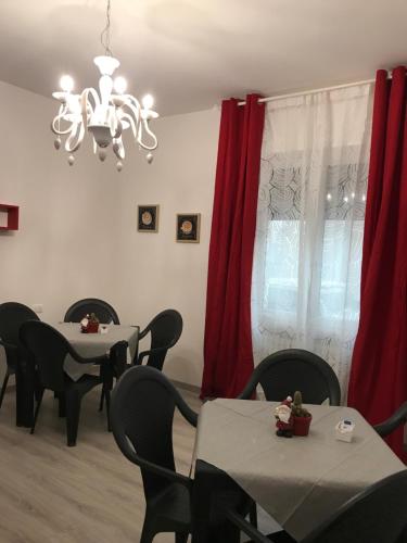 a dining room with tables and chairs and a chandelier at B&B LA CORTE di TIZIANA in San Giovanni Lupatoto