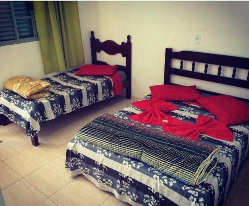 two beds sitting next to each other in a room at Pousada Sol e Lua in São Thomé das Letras