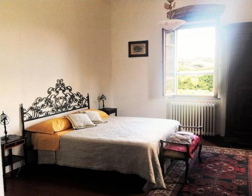 a bedroom with a large bed and a window at Stunning Country House overlooking Tuscany hills in Lorenzana