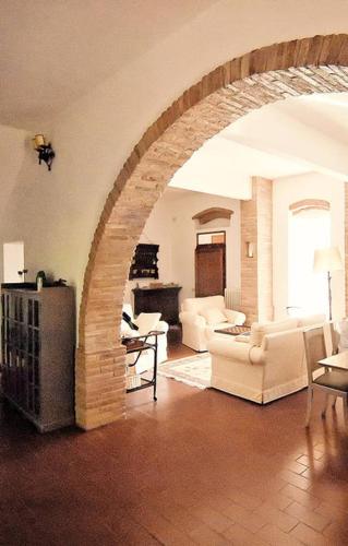 an archway in a living room with white furniture at Stunning Country House overlooking Tuscany hills in Lorenzana