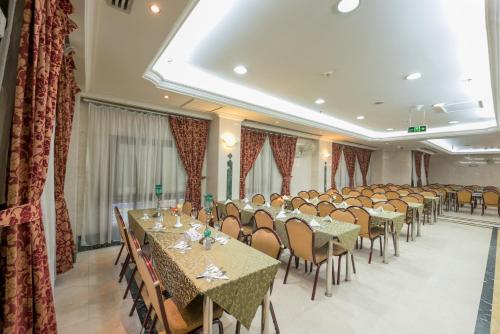 麥地那的住宿－Al Mukhtara Golden，宴会厅配有桌椅和窗帘