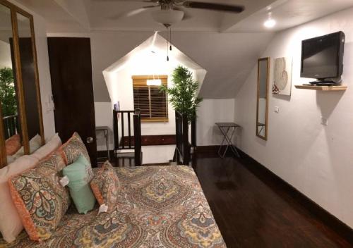 a living room with a couch and a tv at The Oasis Retreat in Nassau