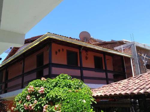 a building with a tree in front of it at Pousada & Kitnet Nascer do Sol in Ilha de Boipeba