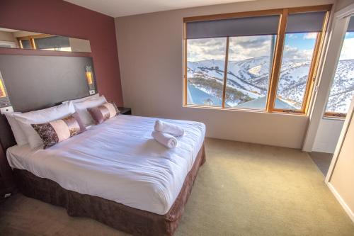 1 dormitorio con 1 cama y vistas a la montaña en Absollut, en Monte Hotham