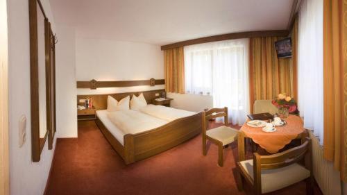 una habitación de hotel con una cama y una mesa con una mesa en Hotel Sonne, en Tux