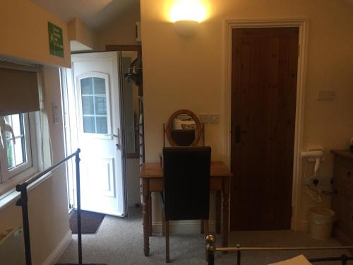 a hallway with a door and a table and a mirror at Findon Rest Ltd in Worthing