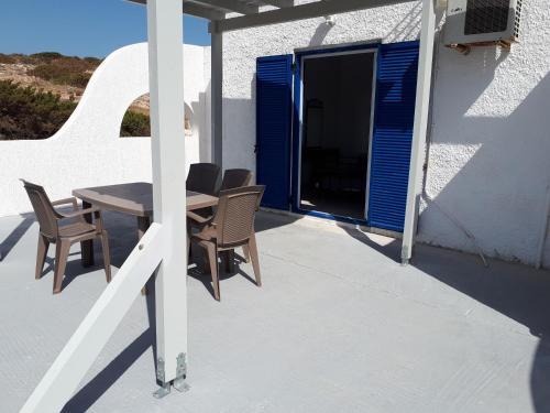 a patio with a table and chairs on a house at Sunset in Iraklia