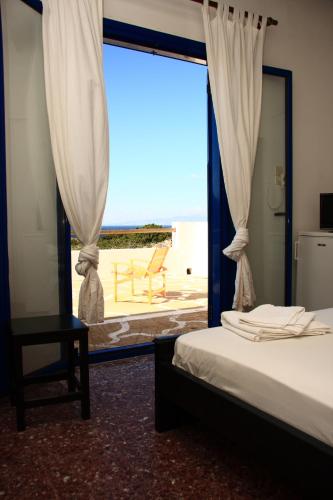 a bedroom with a bed and a window with a view at Sunset in Iraklia